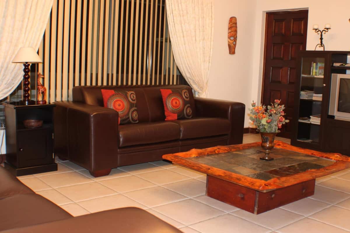 Spacious Garden View Apartment | Área de sala de estar | Televisión LCD de 32 pulgadas con canales digitales y televisión
