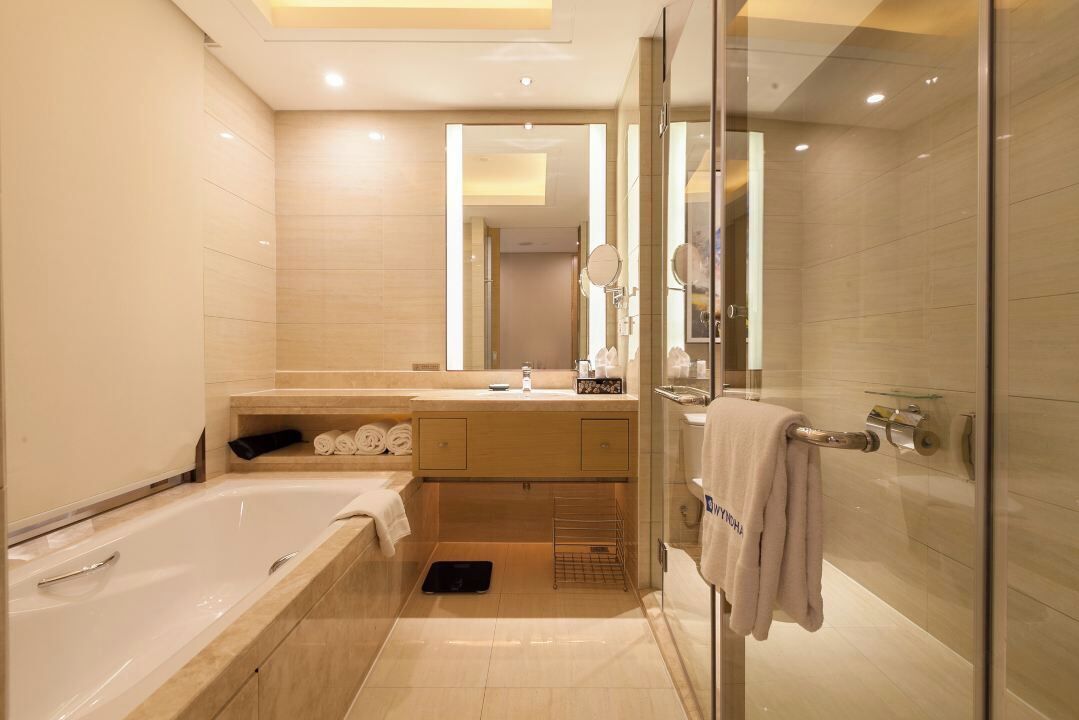 A modern bathroom with a bathtub, a glass shower enclosure, a vanity with a mirror, and a towel rack.