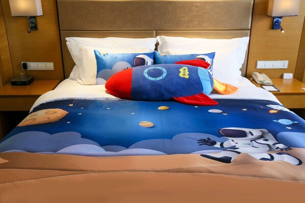 A hotel room with a bed featuring a space-themed bedspread, pillows, and a nightstand with a phone and a lamp. - Wyndham Jingzhou (Jingzhou)
