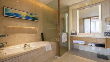 A modern bathroom with a glass-enclosed shower, a large mirror, and a marble sink.