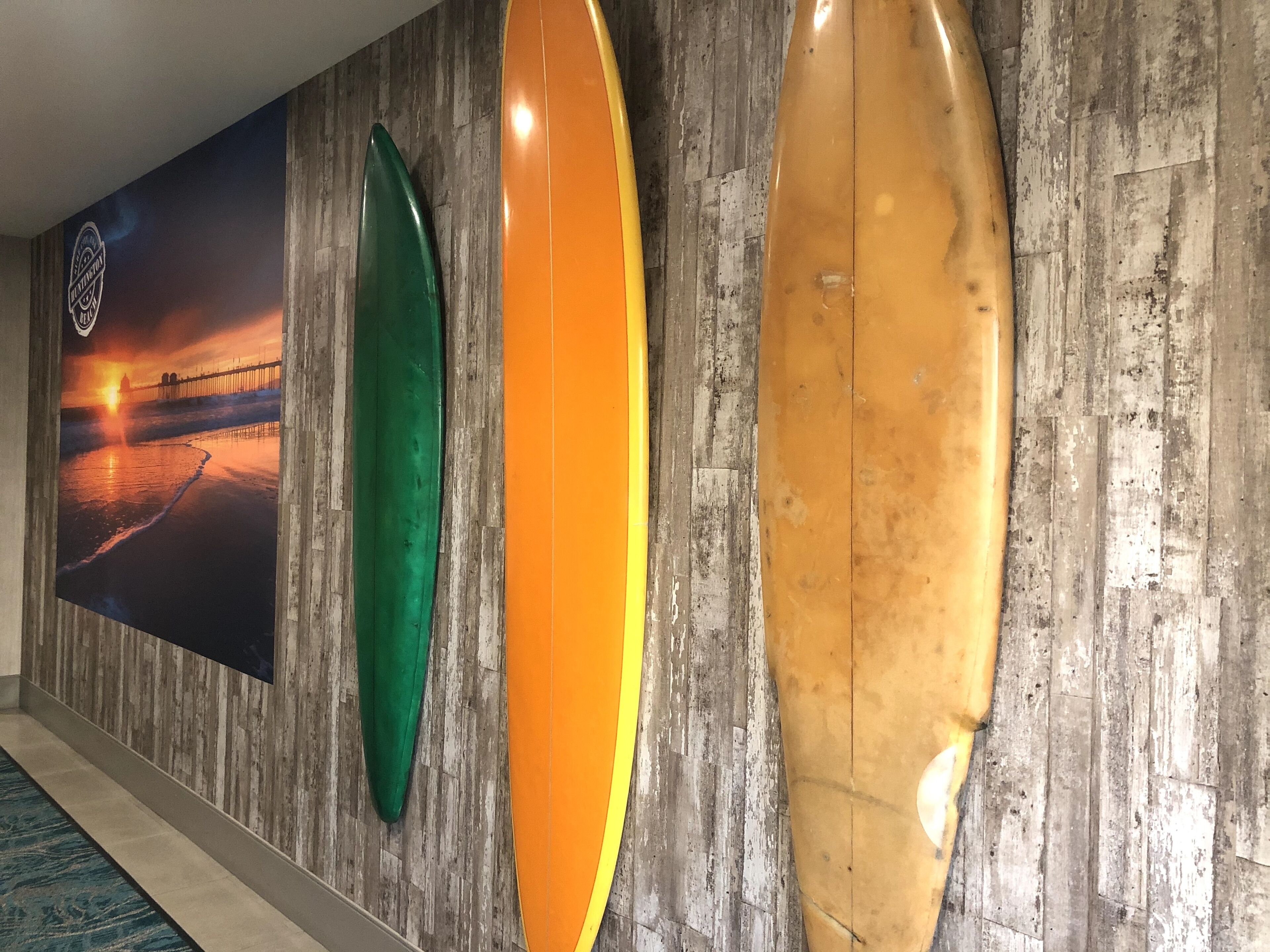 A wall with surfboards and a sunset poster.
