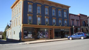 A multi-story building with a blue facade, large windows, and a ground-floor storefront. - Bristol Suites (Bristol)