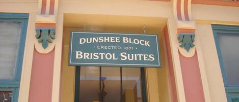 Un edificio con un letrero que dice "Dunshee Block Erected 1871 Bristol Suites".