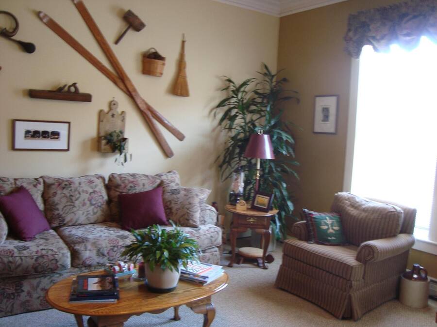 A living room with a floral sofa, a wooden coffee table, a potted plant, and a lamp.