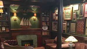 A cozy room with a fireplace, a bookshelf, and a comfortable seating area with a lamp. - Bristol Suites (Bristol)