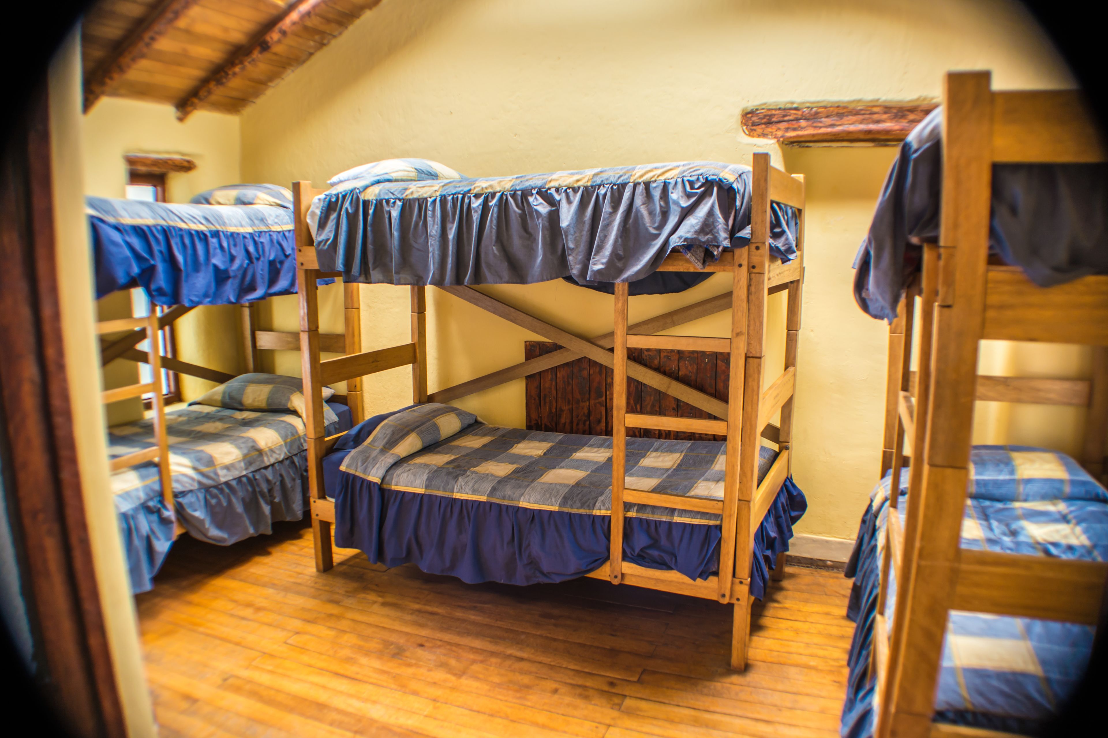 Ein Zimmer mit Etagenbetten, Holzboden und schrägem Dach.