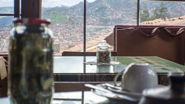 Una mesa con vista a un paisaje urbano a través de una ventana.