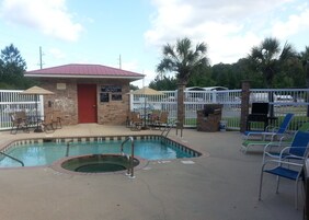 Una piscina al aire libre, sillones reclinables de piscina