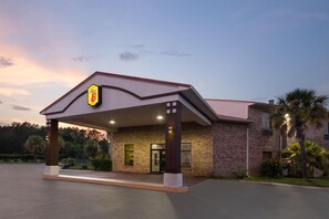 Un hotel con fachada de ladrillo, un acceso cubierto y un letrero que indica que es un Super 8.