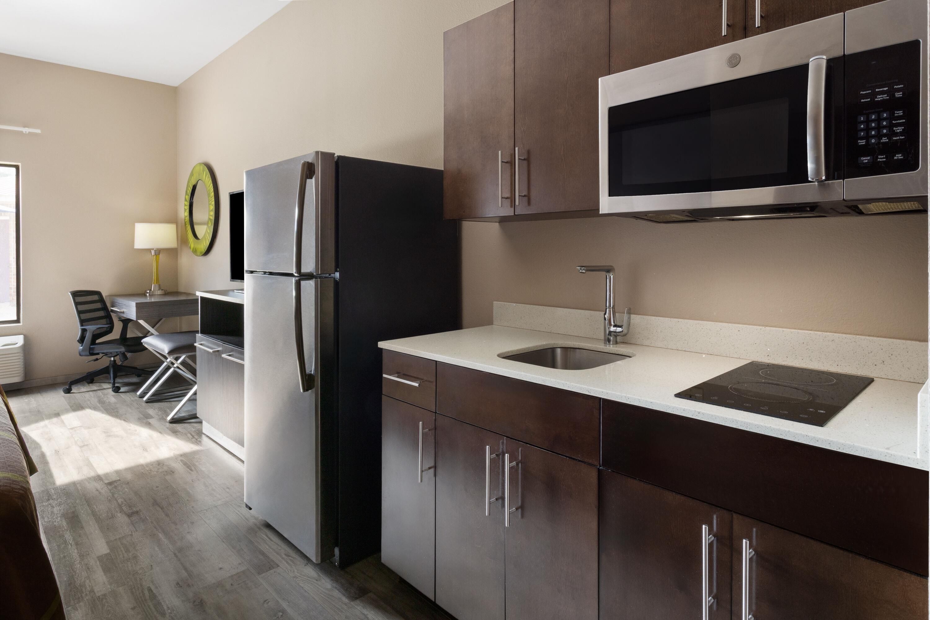 A modern kitchen with stainless steel appliances, a built-in microwave, and a sink.