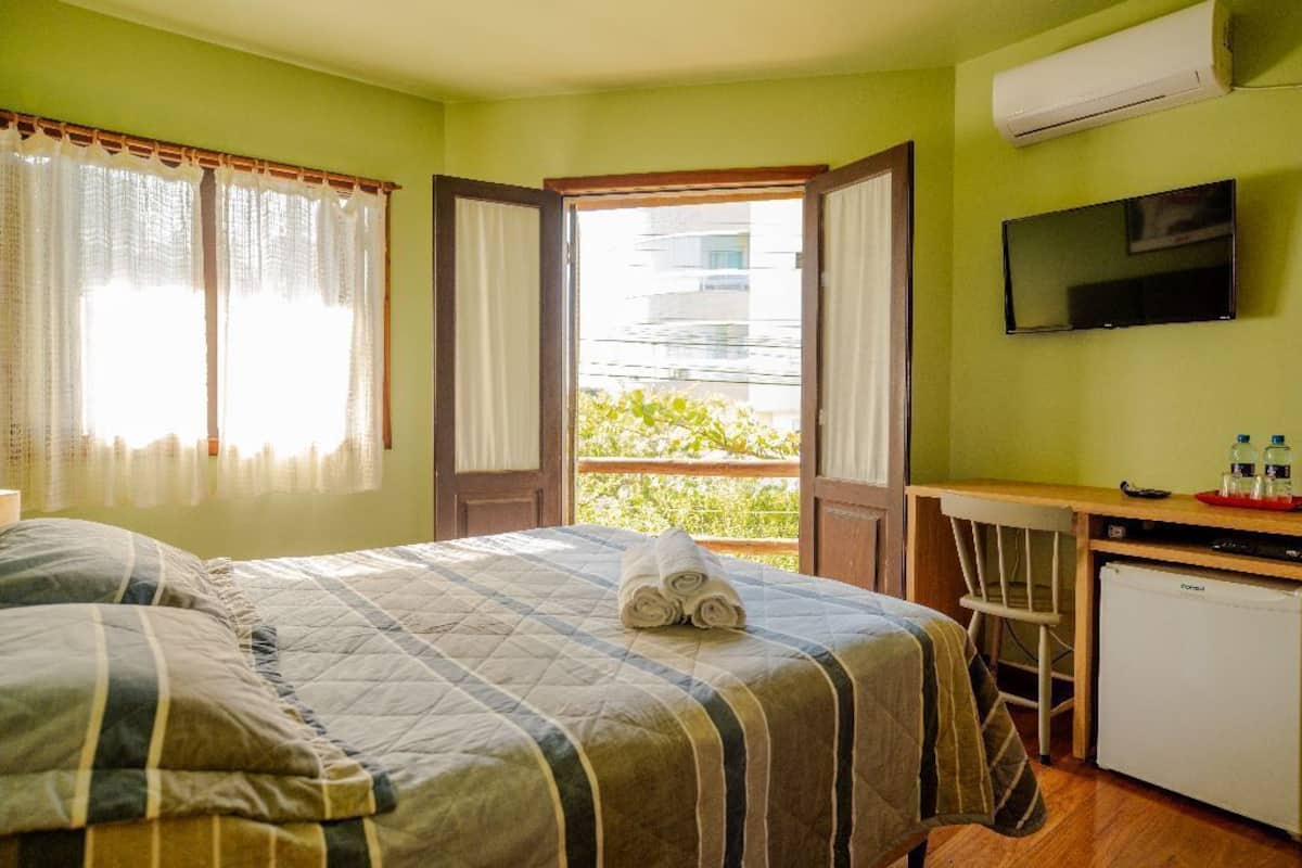 Una habitación de hotel con cama, escritorio, silla y televisión.