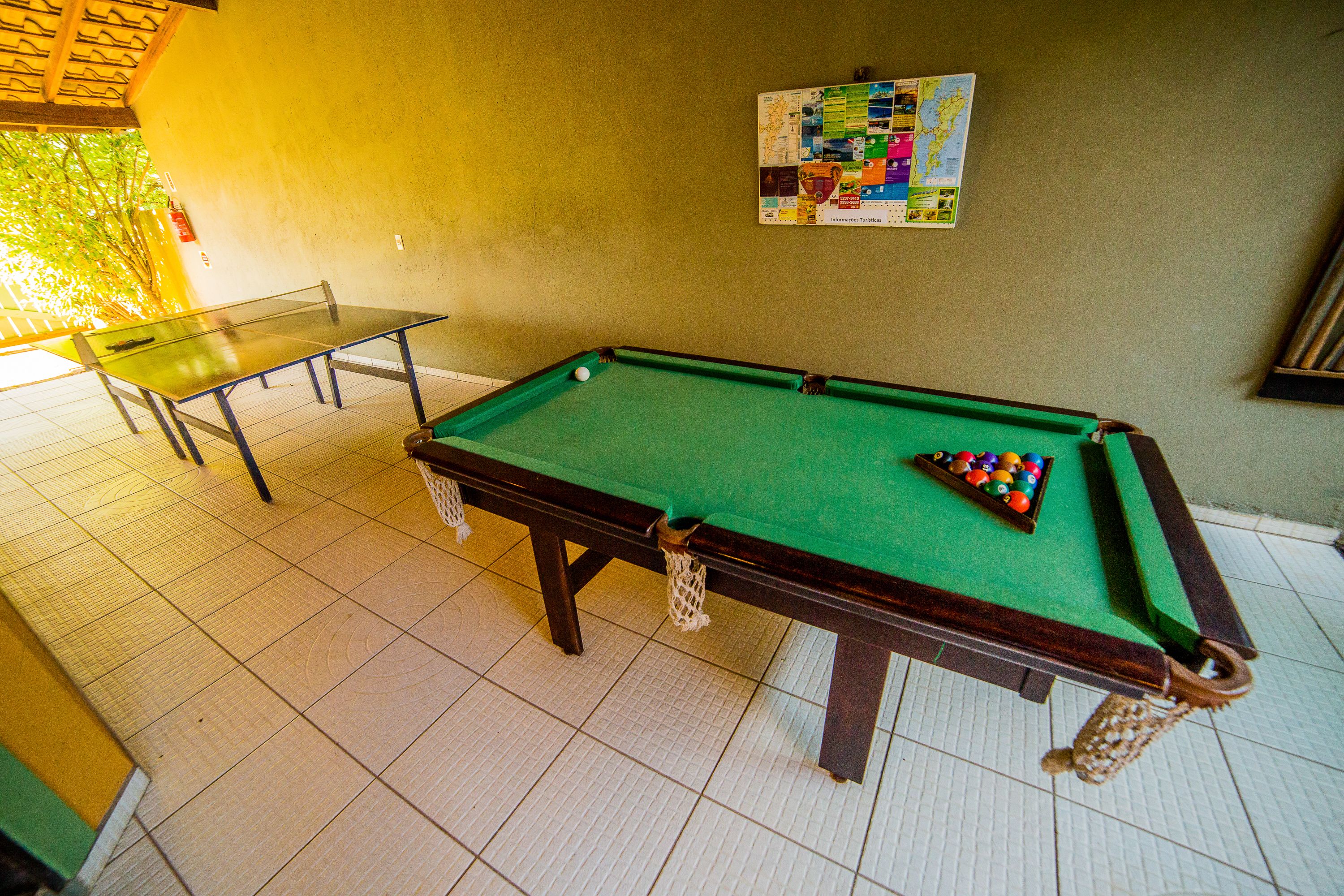 A pool table with a green felt surface and a set of billiard balls.