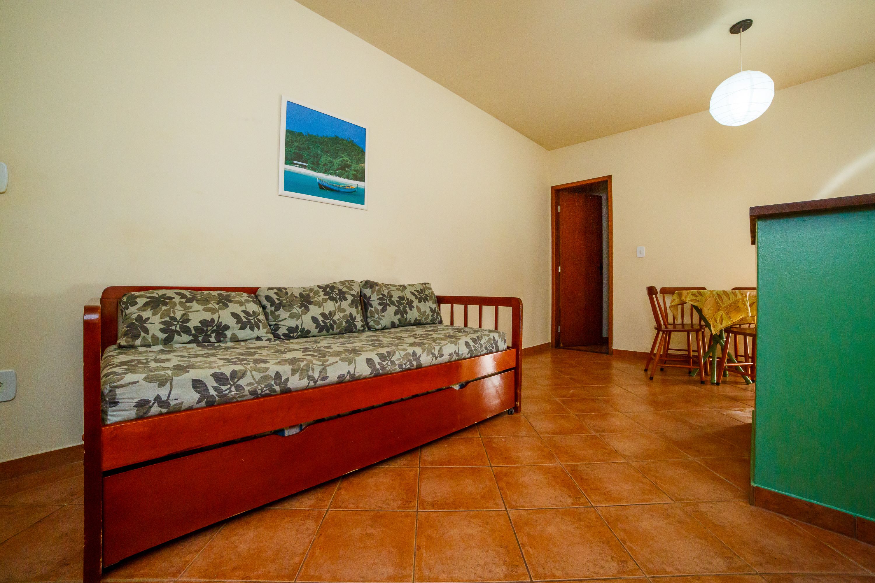 Una habitación con un sofá, una mesa de comedor con sillas y una puerta.