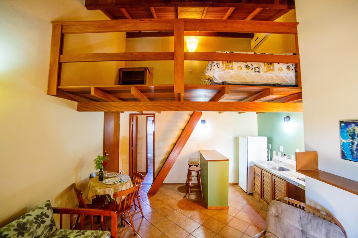 Una habitación tipo loft con comedor, cocina y una pequeña zona de estar.