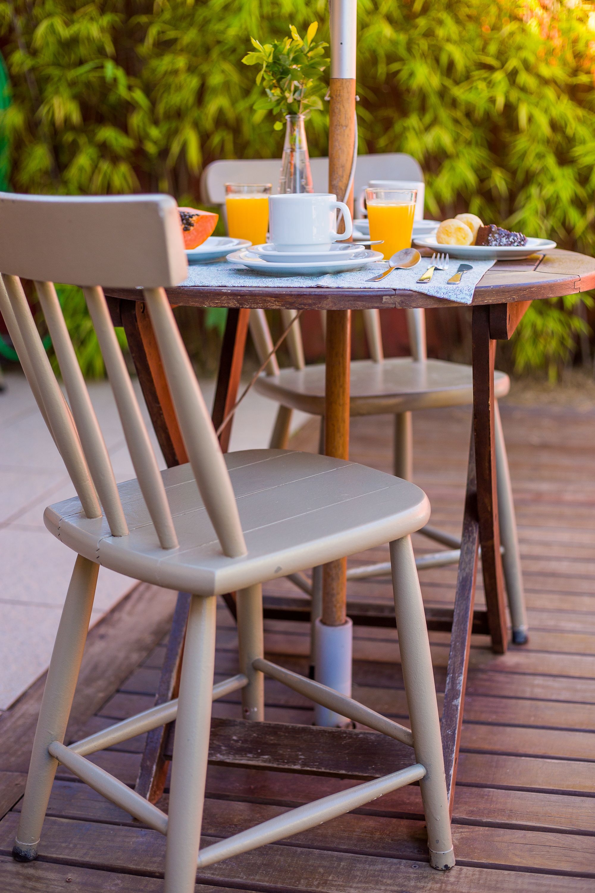 Een eettafel met borden, bestek en een glas sinaasappelsap.