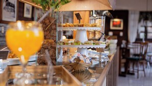 A buffet with a variety of food items and a glass of orange juice. - Pousada Caliandra da Serra (Canela)