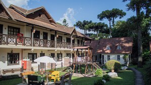 A traditional building with a wooden balcony, a play area, and a well-maintained garden. - Pousada Caliandra da Serra (Canela)