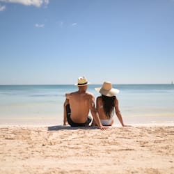 En la playa, arena blanca, sillas reclinables de playa, sombrillas