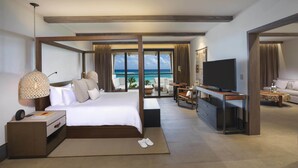 Une chambre d’hôtel moderne dotée d’un grand lit, d’un bureau, d’une télévision et offrant une vue sur l’océan.