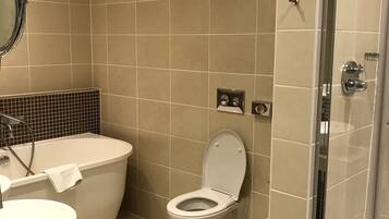 Ein modernes Badezimmer mit Badewanne, Toilette und einer Duschkabine.