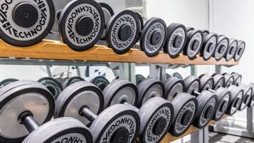 A rack of dumbbells with the brand name "TECHNOLOGY" visible on the weights.