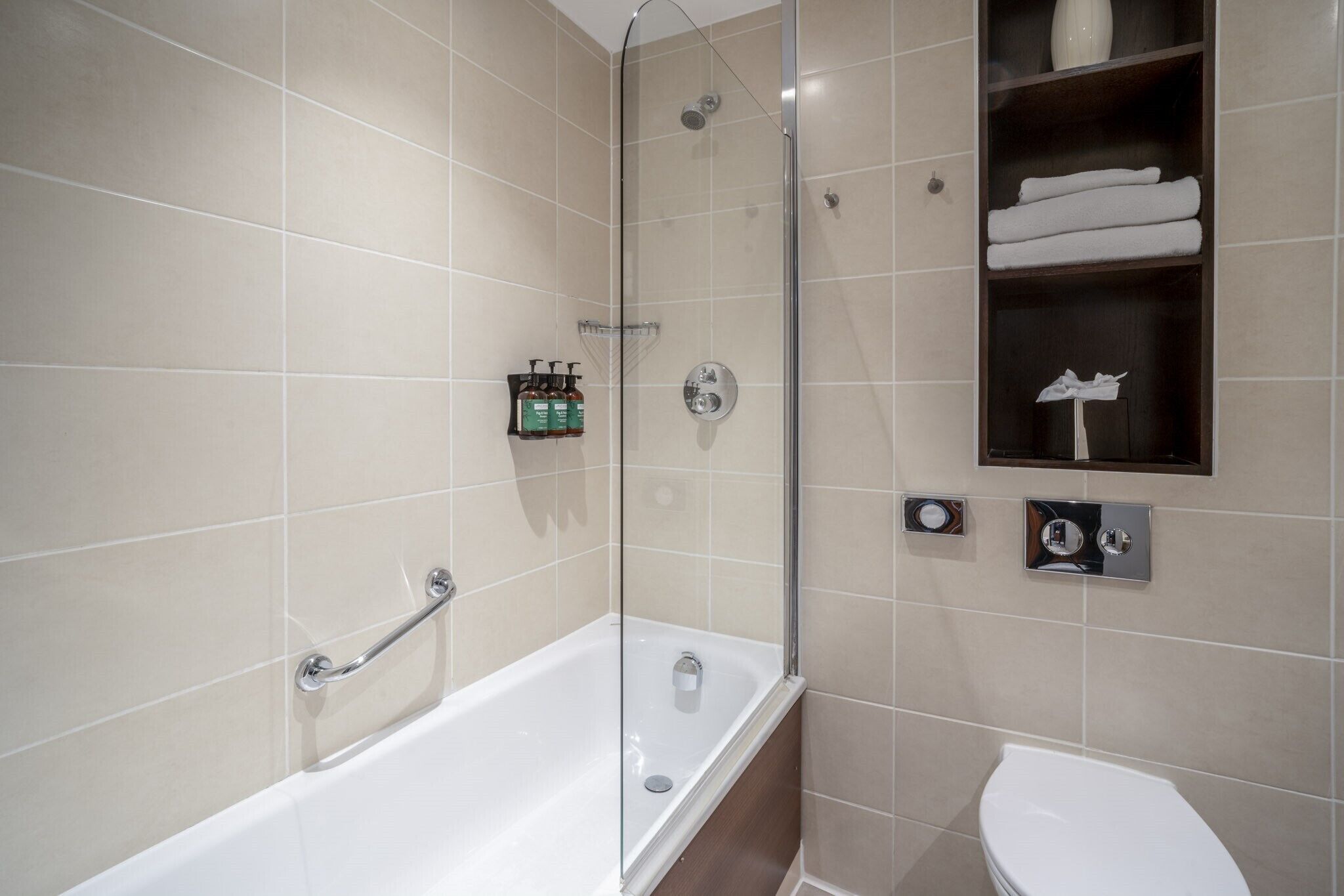 Ein modernes Badezimmer mit einer gläsernen Duschkabine, einer Badewanne und einem WC.