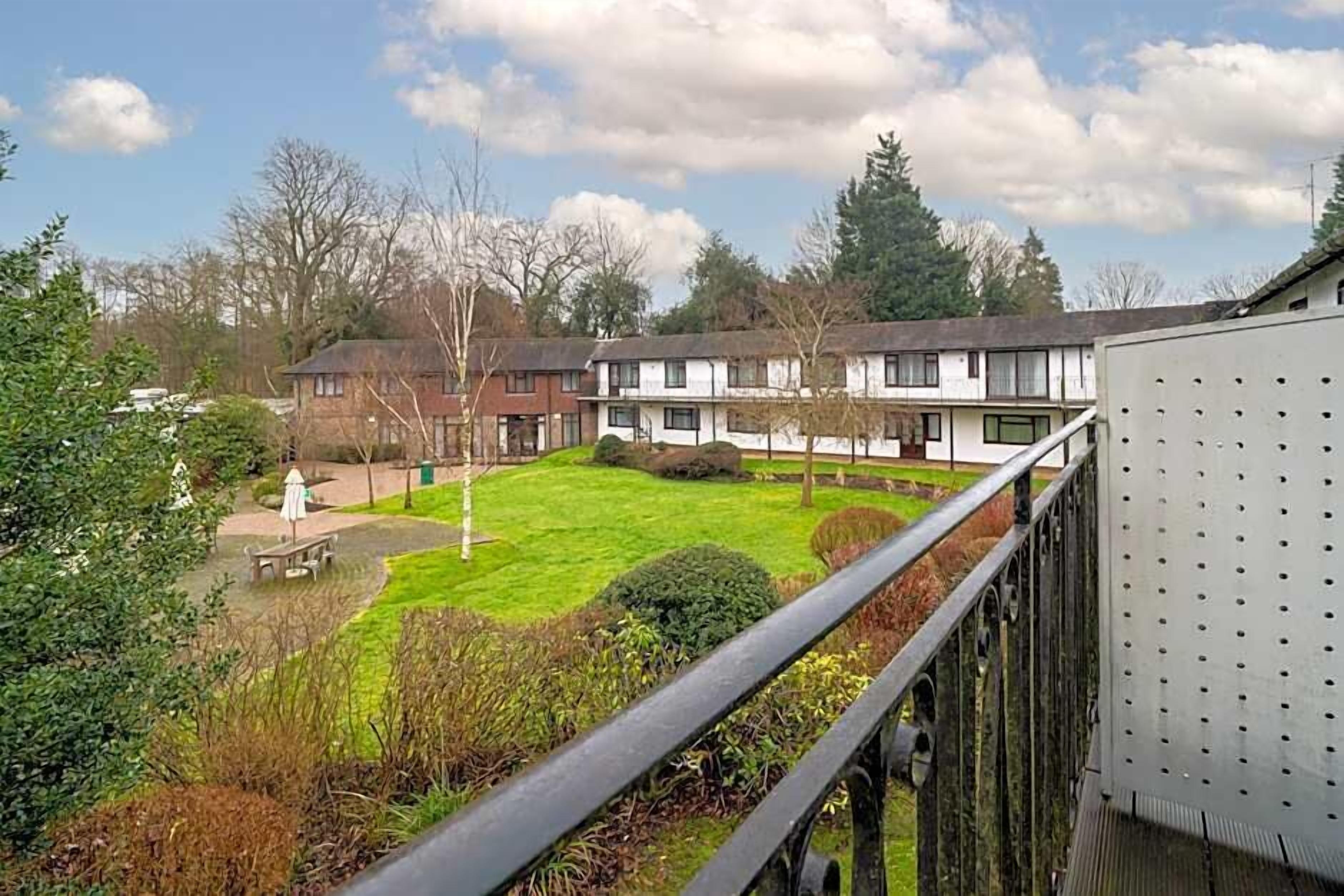 Een woonwijk met meerdere twee verdiepingen tellende huizen, een gazon en een metalen hek.
