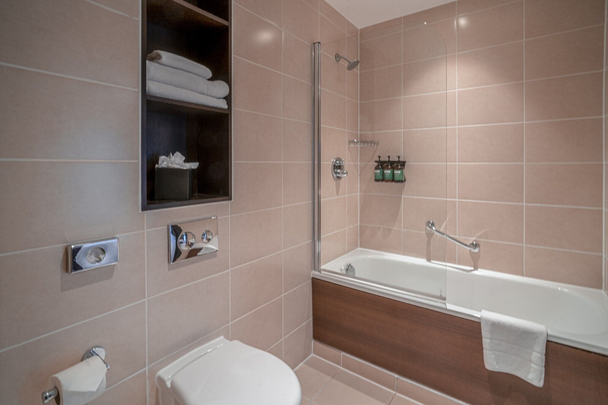 A modern bathroom with a bathtub, a toilet, and a shower area.