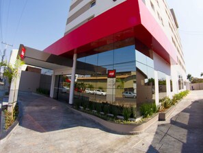 A modern building with a red awning, a glass facade, and a sign indicating a business or service. - ibis Catalao (Catalao)