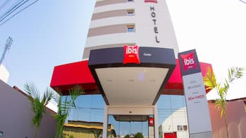 Un hotel de diseño moderno, que destaca el logotipo de 'ibis', una entrada de cristal y una decoración en rojo y blanco.