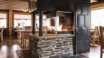 Cozy space with a warm fireplace, wooden furniture, and rustic charm.