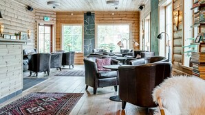 A cozy interior with wooden walls, leather seating, and a stone accent wall. - Storsätra Fjällhotell (Idre)
