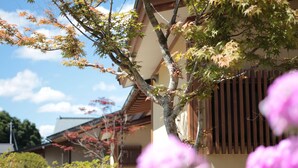 A traditional Japanese building with a sloped roof and wooden shoji screens.