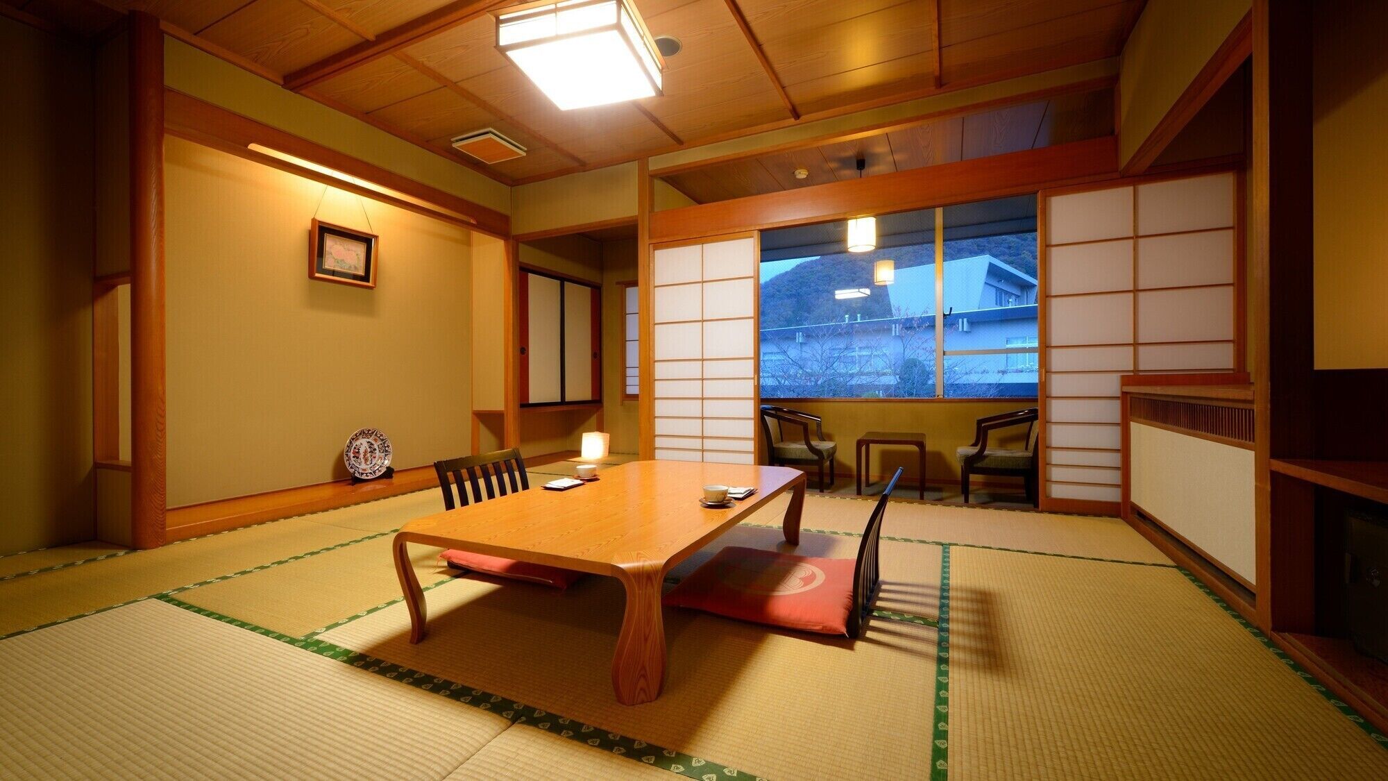 A traditional Japanese room with tatami flooring, a low wooden table, and sliding shoji doors.