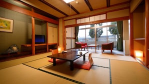 A traditional Japanese room with tatami flooring, a low table, and sliding doors. - Sakaeya Hotel (Tendo)