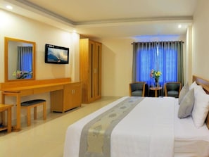 A hotel room with a bed, a desk, a chair, a television, and a wardrobe. - You And Me Hotel (Ho Chi Minh City)
