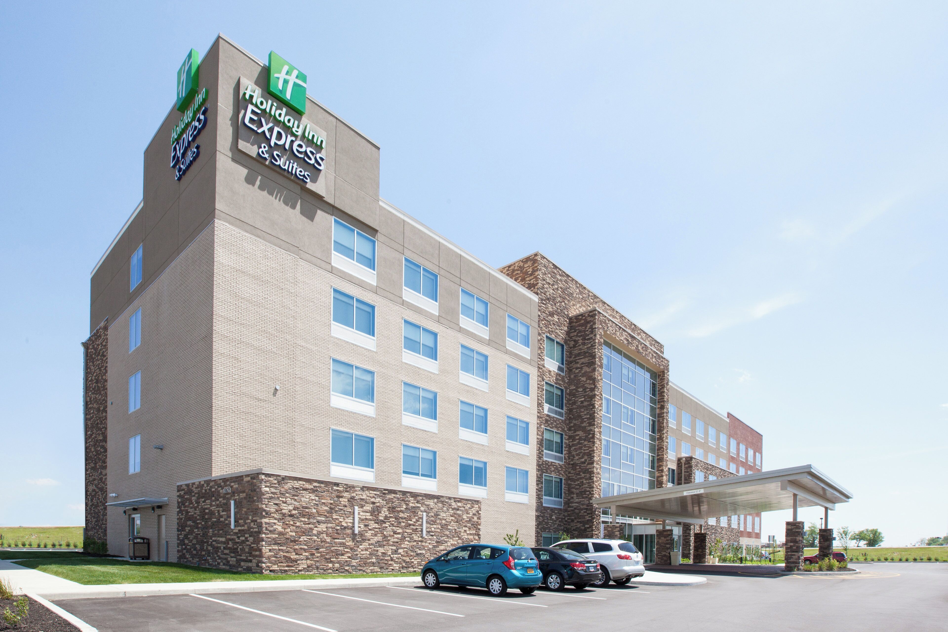 A Holiday Inn Express hotel with a brick facade, multiple windows, and a parking lot with cars.