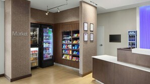 A hotel reception area with a market section, including a refrigerated display and snack shelves. - Fairfield Inn & Suites by Marriott Richmond Ashland (Ashland)