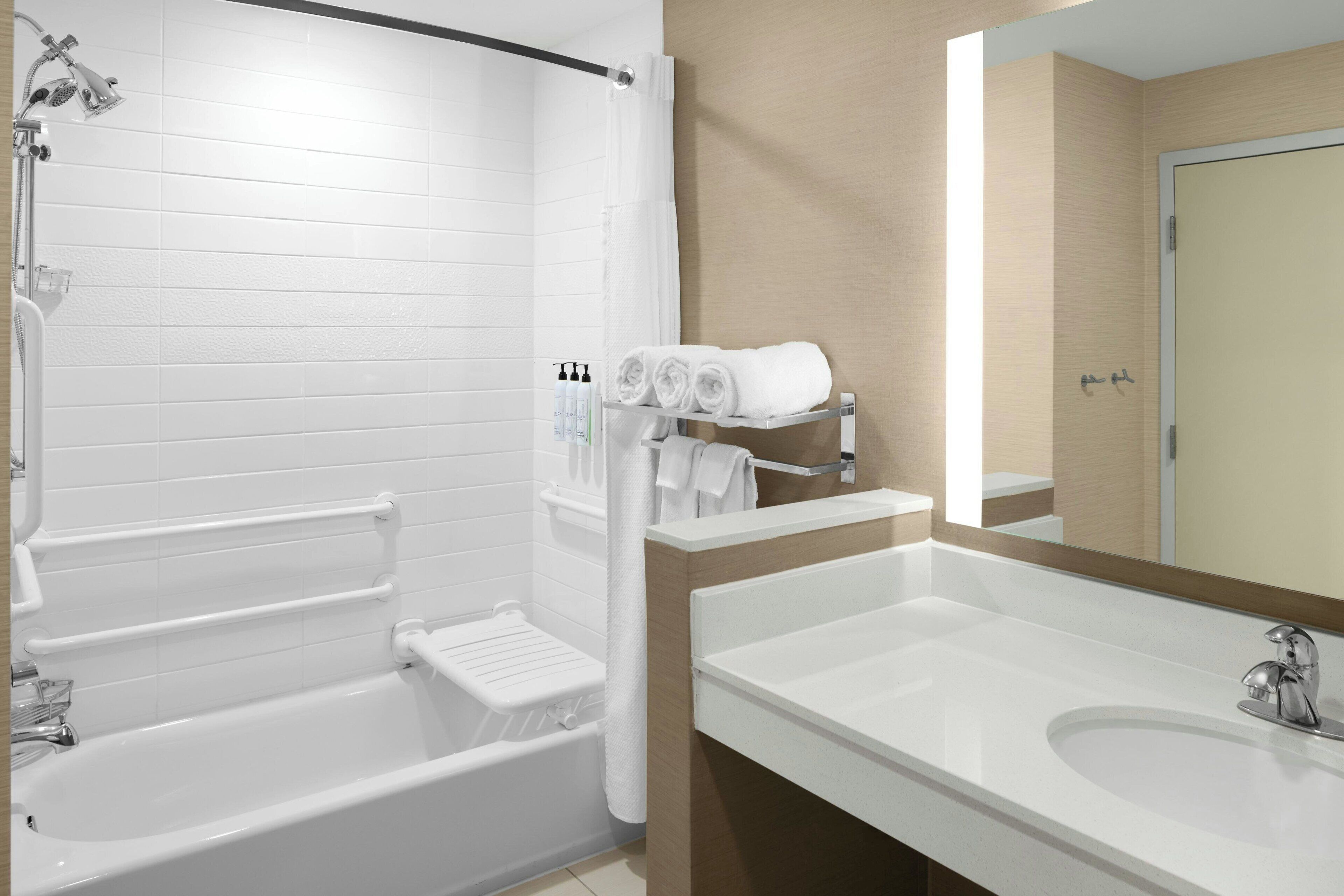 A modern bathroom with a bathtub, a large sink, and a mirror.