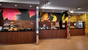 A modern hotel lobby with a wooden reception desk, a coffee machine, and a refrigerator. - Fairfield Inn & Suites by Marriott Alexandria (Alexandria)