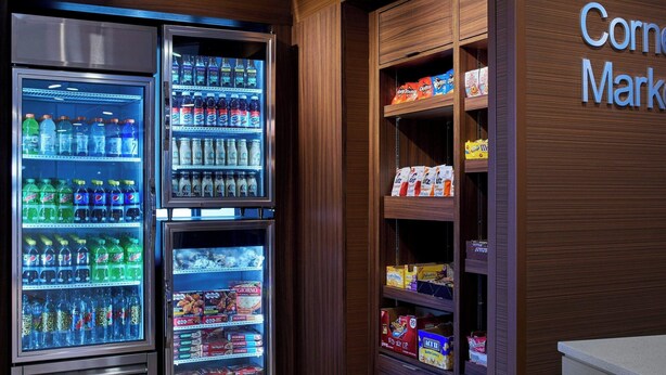 A corner of a store with refrigerated beverage dispensers and shelves stocked with snacks and other items. - Fairfield Inn & Suites by Marriott Alexandria (Alexandria)
