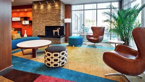 A modern lobby with a stone fireplace, comfortable seating, and large windows. - Fairfield Inn & Suites by Marriott Alexandria (Alexandria)