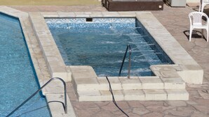 A swimming pool with a tiled edge, a metal ladder, and a white chair. - Hotel Arenales (Villa Carlos Paz)
