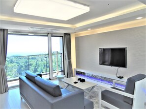 Un salon moderne avec un canapé, une table basse et un téléviseur à écran plat fixé au mur.