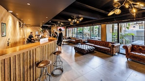 Un bar moderno con detalles de madera, asientos de cuero y un ventanal con vistas al exterior.