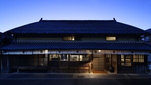 Edifici japonès tradicional amb teules i una entrada de fusta.