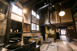 Un intérieur spacieux avec de hauts plafonds, de grandes fenêtres et un luminaire central.