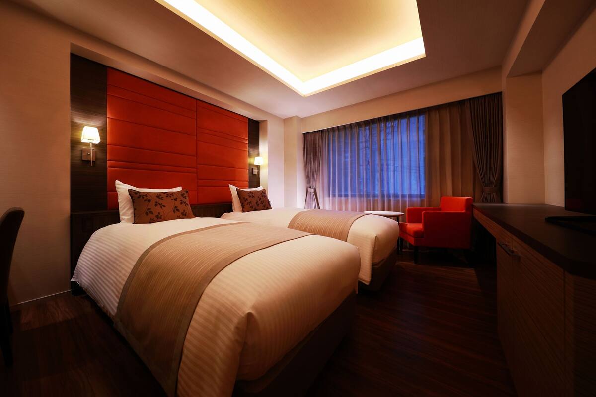 Una habitación de hotel con una cama grande, un escritorio y una silla.
