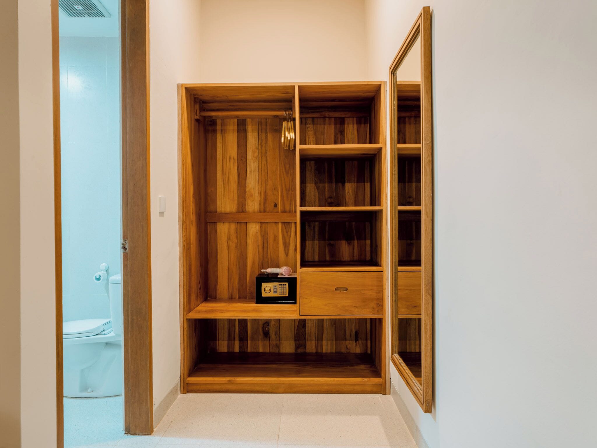 A wooden wardrobe with multiple shelves and a small radio.