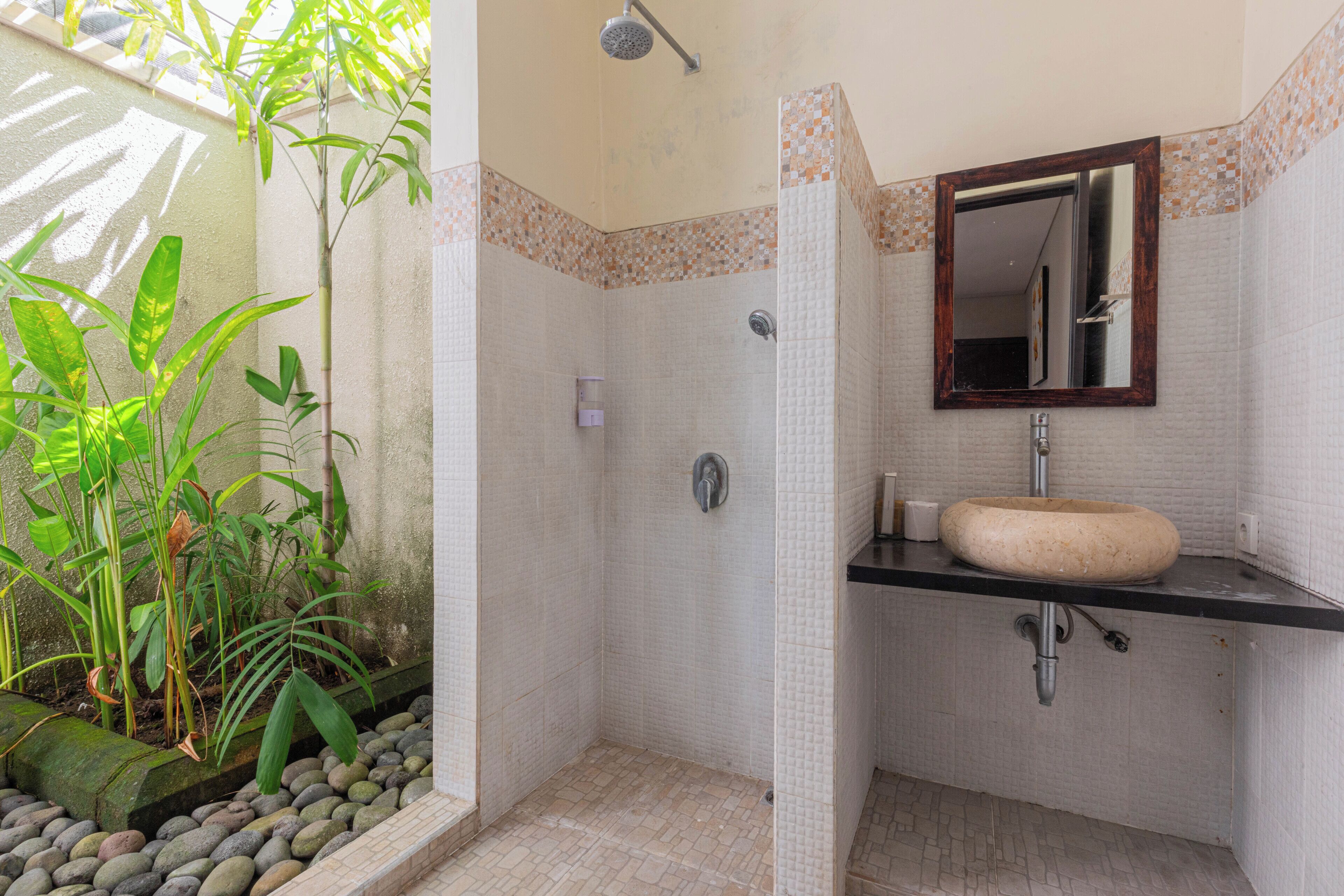 A bathroom with a shower, a sink, and a mirror.
